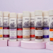 Row of Colournance hair care products on pink stands against a light purple background