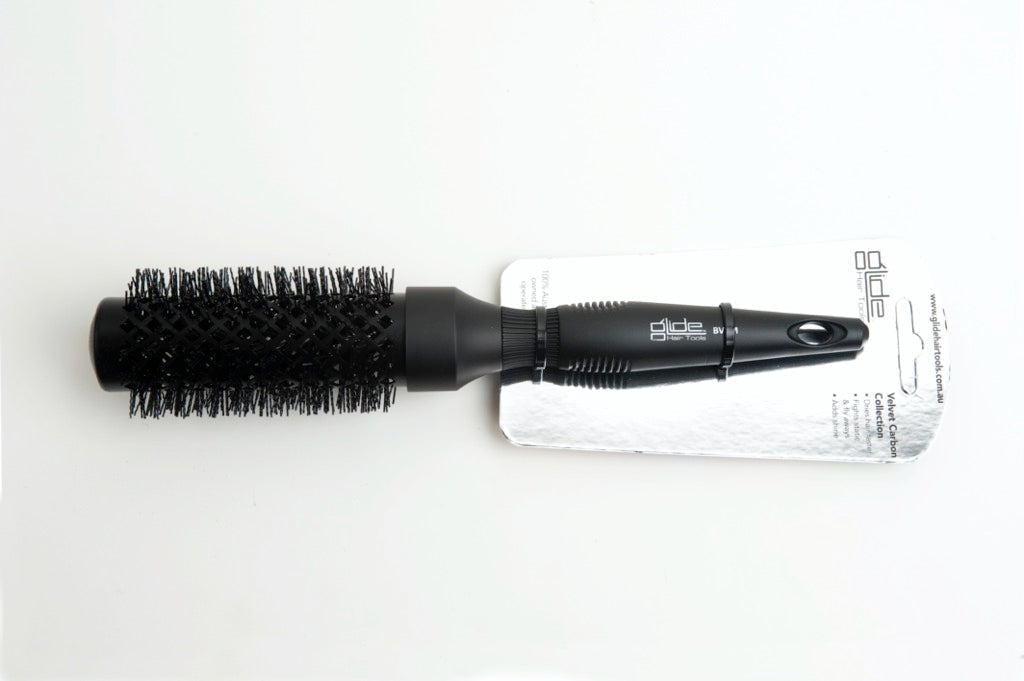 Black hairbrush with packaging on a white background
