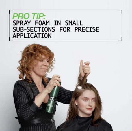 Person applying Redken Root Lifter hair product to another person with text overlay about spray foam application.